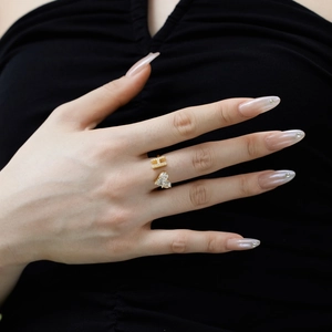 Close-up of adjustable H-letter and heart zircon gold ring worn by a female model