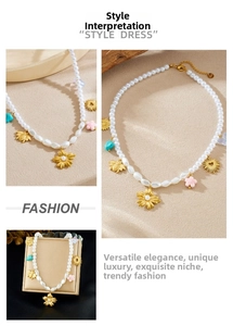 Détail du collier de perles dorées avec pendentifs marguerite, abeille, cœur et turquoises