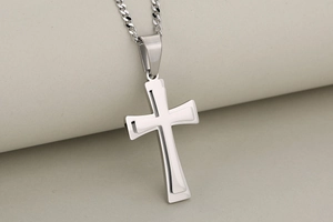 Detailed view of silver double-layered stainless steel cross pendant on fine chain