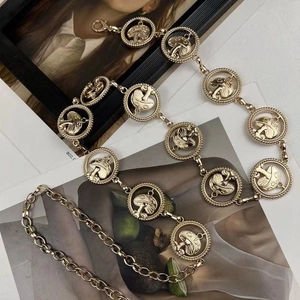 Detail of golden metal chain belt featuring round links with mushroom patterns