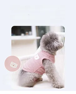 Close-up of pink waffle fabric pet vest with bear embroidery on a grey poodle