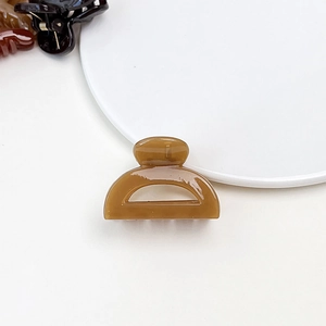 Macro view of a caramel translucent acrylic hair claw clip on white background