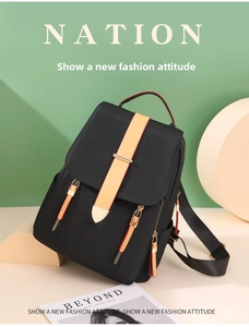 Detailed view of black Oxford cloth backpack with orange straps and multi-pocket design