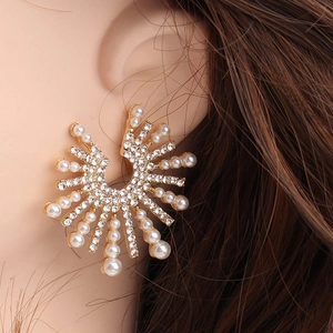 Detailed view of large alloy sunflower earrings with crystals and white imitation pearls
