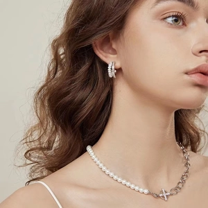 Elegant pearl and silver cross jewelry set featuring a necklace and hoop earrings