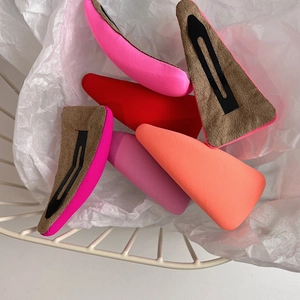 Colorful sponge hair clips in pink and coral displayed in a white wire basket