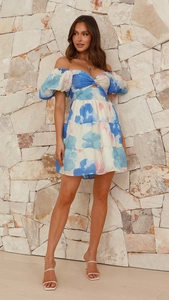 Détail de la robe à fleurs élégante avec col en V évidé et manches bouffantes de style