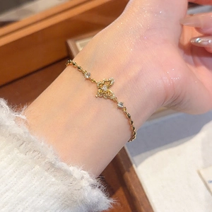 Detail of 18k gold plated butterfly bracelet with sparkling zircon on a woman wrist