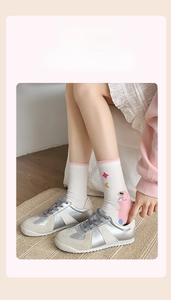 Détail d'une chaussette blanche en coton avec motif lapin rose et étoiles mi-mollet