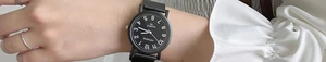 Close-up of minimalist black quartz watch with white Arabic numerals on a wrist