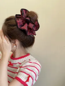 Detail of red and black checkered scrunchie styled on a classic bun hairstyle
