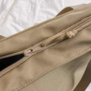 Minimalist canvas tote bag in khaki showing high-quality zipper detail and woven shoulder strap