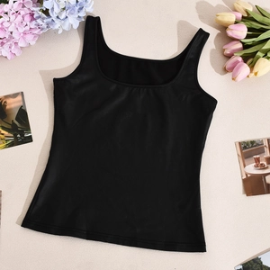 Vista plana detallada del top corto negro con cuello en U y tirantes sobre tela beige