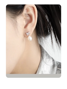 Detail shot of elegant S925 silver stud earring with zircon and drop pearl on model