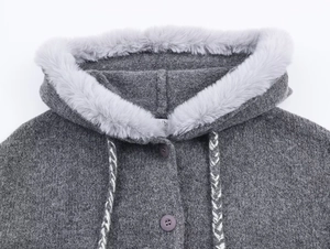 Close-up of knit cardigan featuring faux fur collar and braided drawstring details