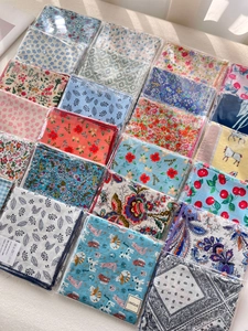 Detail of assorted floral cotton linen scarves with unique prints and brand labels