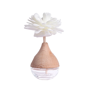 Home fragrance diffuser with white decorative flower and clear glass essential oil bottle