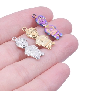 Close-up of three DIY polished stainless steel boy and girl charms on a finger