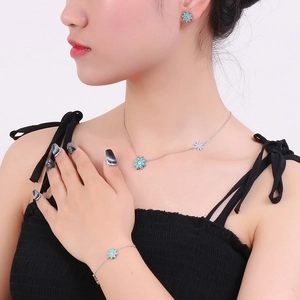 Parure de bijoux élégante avec marguerites en émail vert sur collier, bracelet et boucles