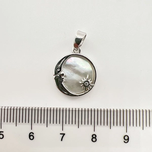 Close-up of 18K gold-plated celestial shell pendant with ruler showing size 1.8cm