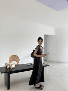 Minimalist summer outfit with purple V-neck top, black maxi skirt and woven straw bag
