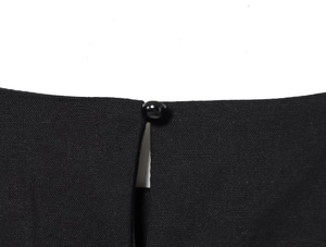 Dettaglio del top nero in lino con chiusura a un bottone e scollo a goccia sul retro