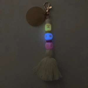 Gros plan d'un porte-clés à perles lumineuses avec pompon et perles fluorescentes
