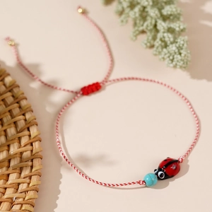 Handmade red and white cotton rope bracelet with ladybug charm and turquoise bead