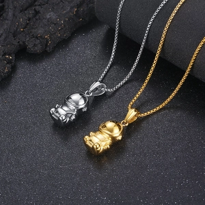 Detailed view of silver and gold astronaut necklaces on a textured black rock background