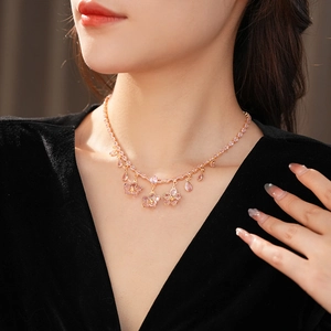 Close-up of model wearing pink zircon flower and water drop pendant necklace set