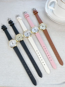 Flat lay of Roman numeral watches with leather straps in black, white, pink, and brown