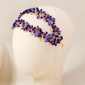 Close-up of blue crystal vine leaf headband with gold metal base on a model