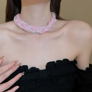 Close-up of pink woven pearl choker necklace on model featuring sweet beaded texture