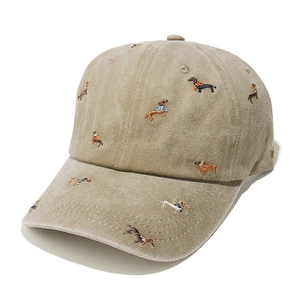 Close-up of the detailed sausage dog embroidery on a vintage washed khaki baseball cap