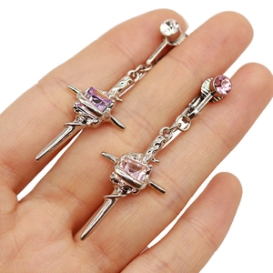 Detail view of silver cross earrings with square purple and pink synthetic gems