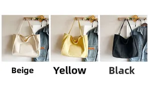Detailed view of canvas tote bags in beige, yellow, and black hanging on wooden hooks