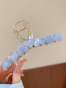 Macro shot of large jelly hair claw clip with light blue 3D hearts on clear acrylic base