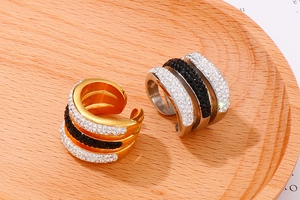 Detailed view of geometric crystal pave rings in gold and silver on a wooden tray