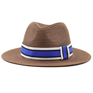 Détail de la texture d'un chapeau de paille marron avec ruban rayé bleu et blanc