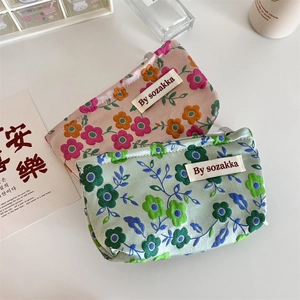 Detail of floral embossed cosmetic pouches with vintage flower patterns and brand labels