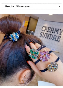 Close-up of four floral crystal rhinestone hair ties in blue, green, pink, and champagne