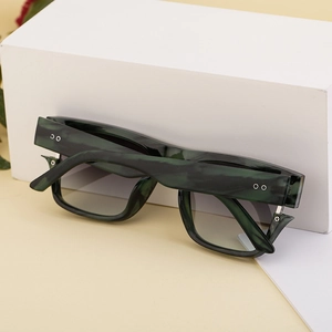 Detail of square oversized sunglasses with dark green marble frame and gradient lenses