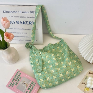 Detail of green floral canvas tote bag with side bow tie and soft fabric texture