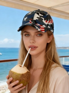 Detail of camouflage baseball cap with US flag design worn by a model in sunlight