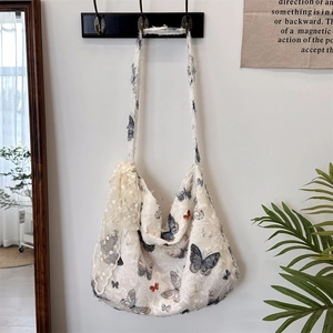 Detailed close-up of butterfly print and white lace floral appliques on canvas tote bag