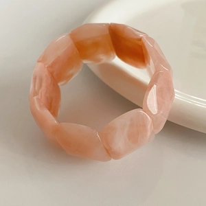 Macro shot of pink marble resin acrylic elastic bracelet with pebble-shaped smooth links