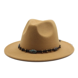 Detail of wool fedora hat featuring a woven band with turquoise beads and metallic charms