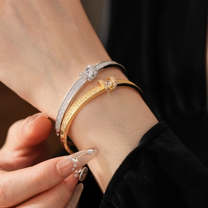 Detail of elegant gold and silver bracelets with micro-pave zircons on a model's wrist