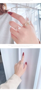 Close-up of a hollow cross ring with a large zircon and pavé crystals on finger