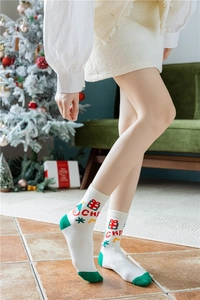 Détail de chaussettes de Noël avec motifs de chapeaux festifs et cadeaux sur fond blanc